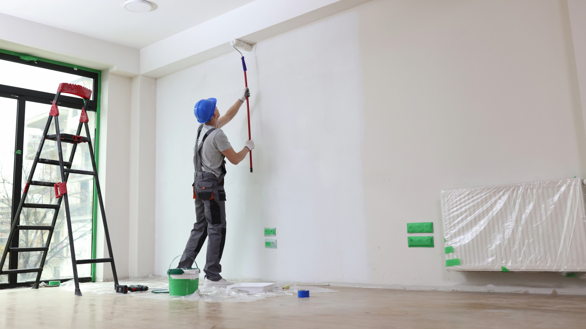 Painter applying paint to an interior wall