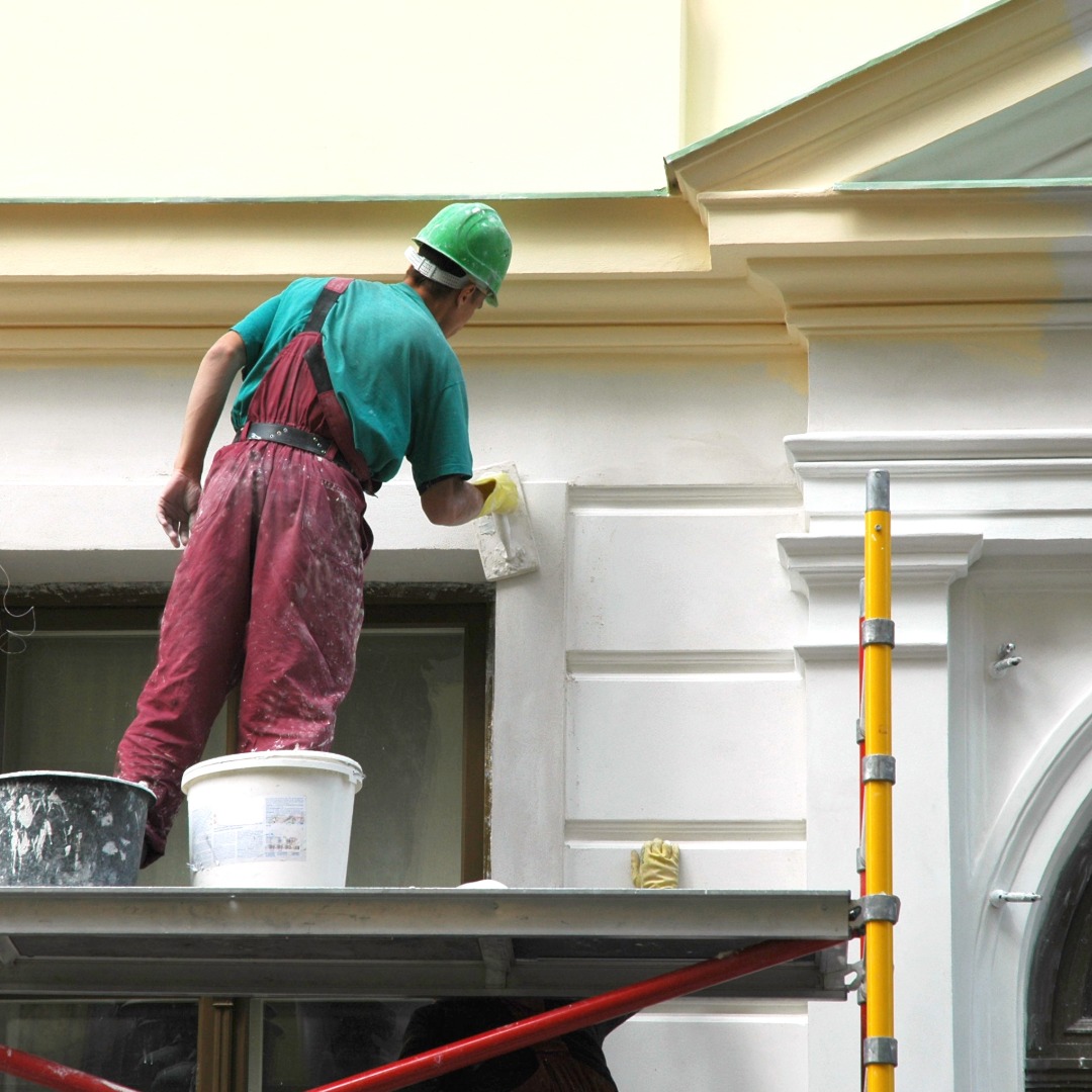 Painter working on the exterior of a building